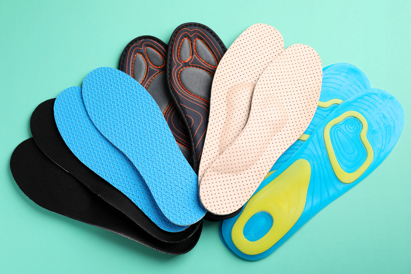 Pairs of Different Shoe Insoles on Turquoise Background, Flat La